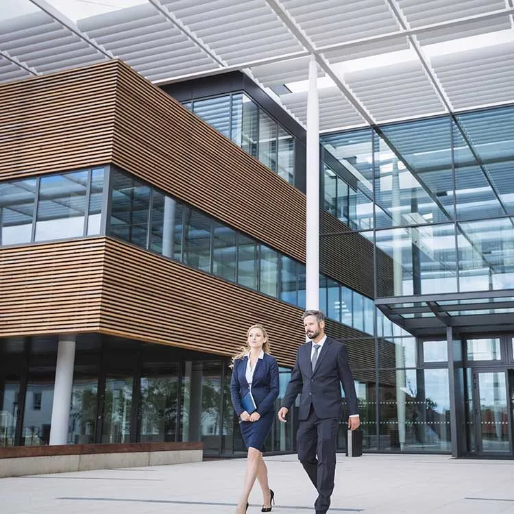 Businessman walking with colleague outside biopharma building web