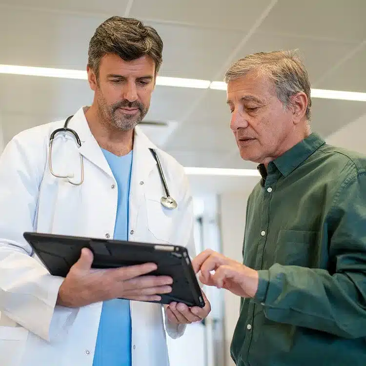 Doctor explaining test results to senior patient in hospital lobby web