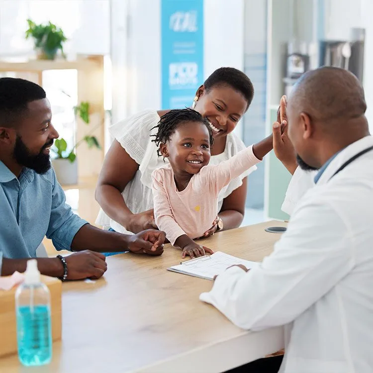 Doctor high fives girl with her parents at the hospital web