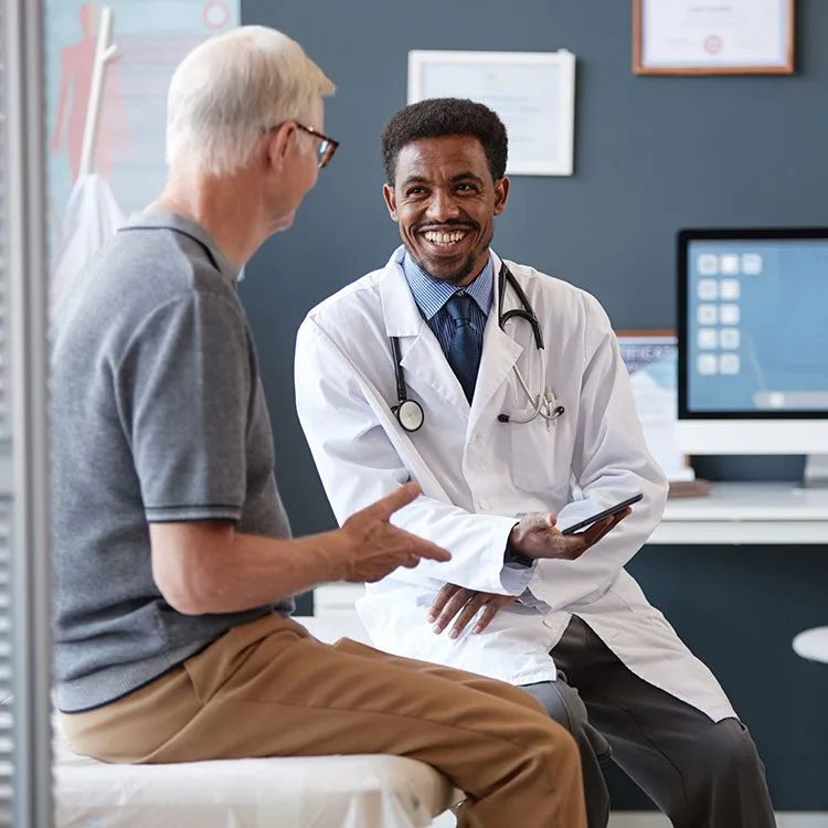 Doctor holding tablet talking to senior patient web
