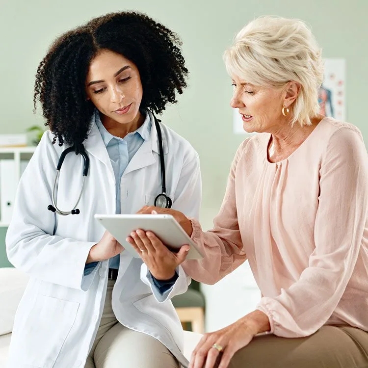 Doctor with tablet consulting mature patient web