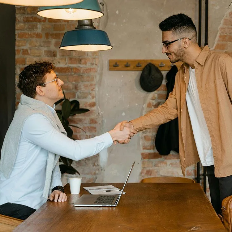 Hiring manager shaking hands with new employee web