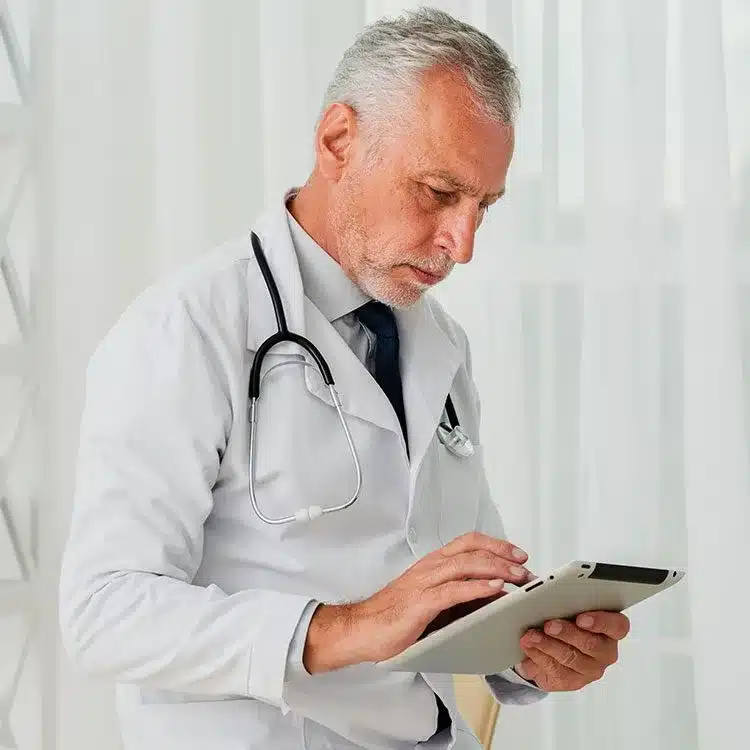 Older doctor using tablet web
