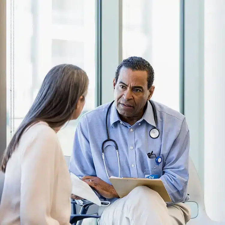 Serious male doctor listens to female patient web